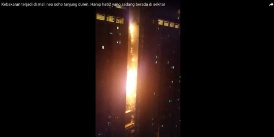 Puing-puing berjatuhan dari gedung Neo Soho yang terbakar