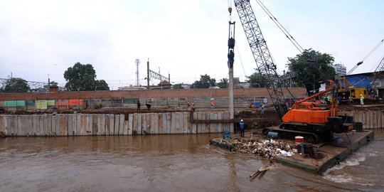 Pemasangan tiang pancang di bantaran Kali Ciliwung