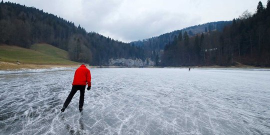 Serunya main es skating di sungai Swiss yang membeku