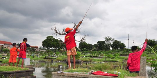 Keseruan anak-anak memancing di tengah kuburan Tanah Kusir