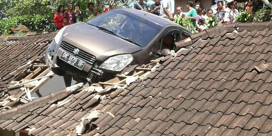 Belajar nyetir, pengemudi hilang kendali mobil nyangkut di atap pura