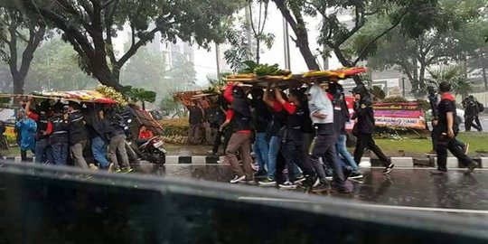 Hujan, karangan bunga untuk Ahok jadi payung buruh