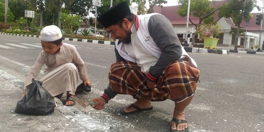 Usai salat Jumat, Said dan anaknya bersihkan lilin bekas aksi Ahok