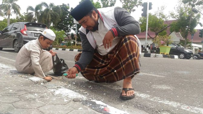 said dan anaknya bersihkan lilin bekas aksi ahok