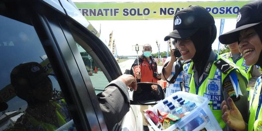 Polwan cantik bagi air mineral untuk takjil di pintu Tol Soker