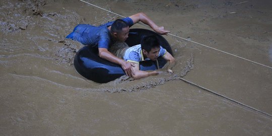 Aksi warga China terjang derasnya banjir bandang dengan ban