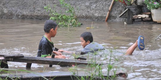 Keceriaan anak-anak bermain di tengah banjir Jati Padang