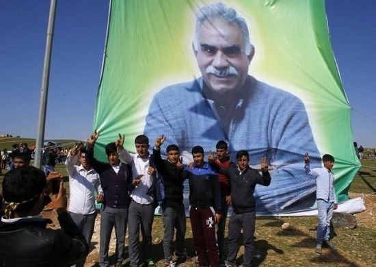 warga kurdi di depan spanduk foto pemimpin pkk abdullah ocalan