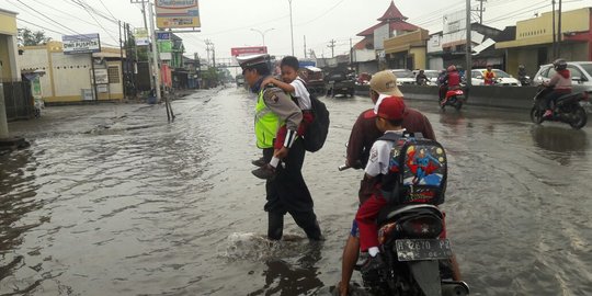 Momen anggota Polsek Genuk gendong anak sekolah agar tak basah saat banjir
