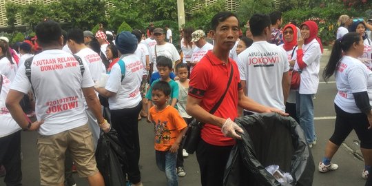 Relawan berkaos #2019TetapJokowi long march sambil pungut sampah di Bundaran HI