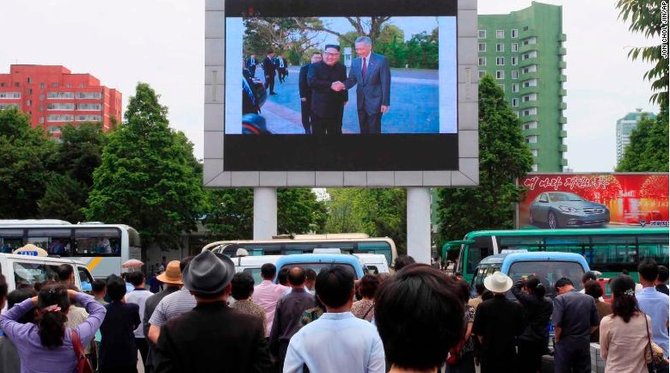 warga menyaksikan pertemuan kim jong un dan pm singapura lee hsien loong dari layar lebar