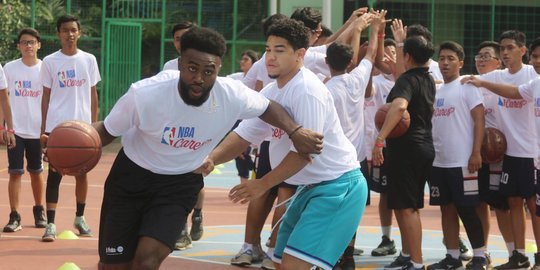 Aksi pemain NBA Jaylen Brown main basket dengan anak-anak