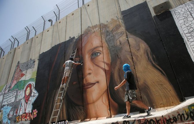 dua seniman italia melukis wajah ahed tamimi di dinding pemisah di betlehem