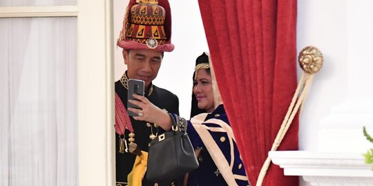 Gaya Jokowi dan Iriana selfie dengan busana daerah di balik pintu istana