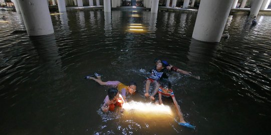 Belum surut, genangan di Terowongan Apron jadi tempat berenang anak-anak