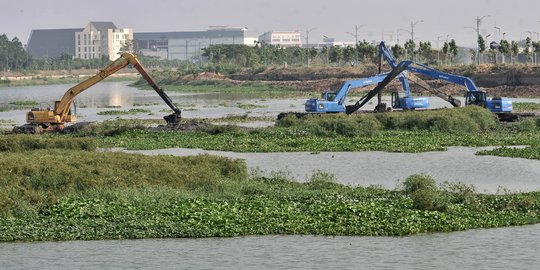 Pengerukan lumpur dan tanaman liar di Kanal Banjir Timur