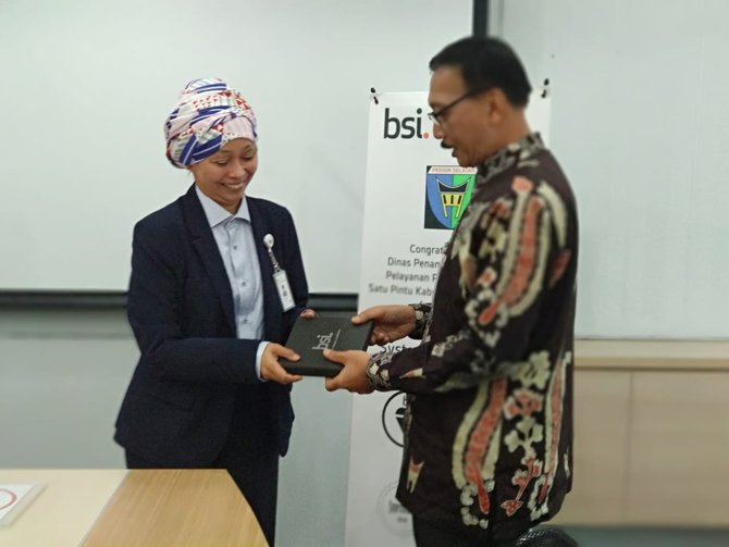 bupati pesisir selatan hendrajoni menerima serifikat iso 90012015 dari managing director bsi indonesia erna damayanti