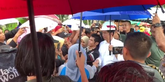 Meski Hujan Deras, Jokowi Layani Warga yang Berebut Salaman dan Foto