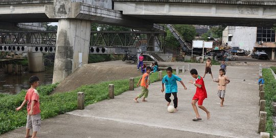 Serunya Anak-Anak Bermain Sepak Bola di Jalur Inspeksi Ciliwung
