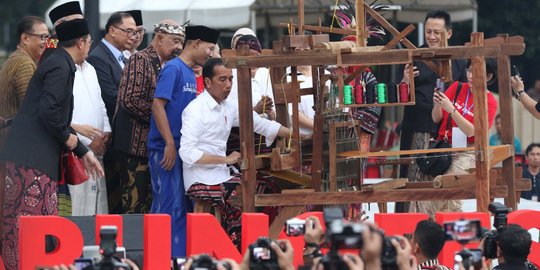 Aksi Jokowi Jajal Alat Tenun di Festival Sarung Indonesia 2019