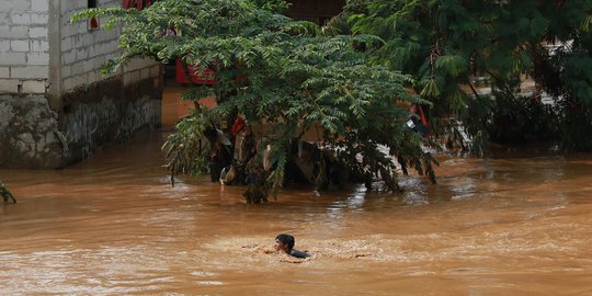 Kenekatan Anak-anak Berenang di Sungai Ciliwung yang Meluap