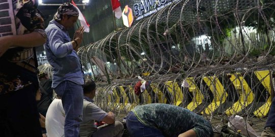 Massa Buka Puasa dan Salat Maghrib di Depan Kawat Berduri Bawaslu