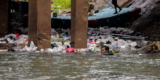 Perjuangan Petugas PPSU Bersihkan Sampah di Derasnya Aliran Kali Ciliwung