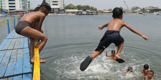 Keceriaan Anak-Anak Bermain di Tanggul Laut