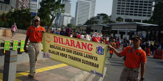 Aksi Satpol PP Bentangkan Spanduk Larangan PKL Berjualan di Car Free Day