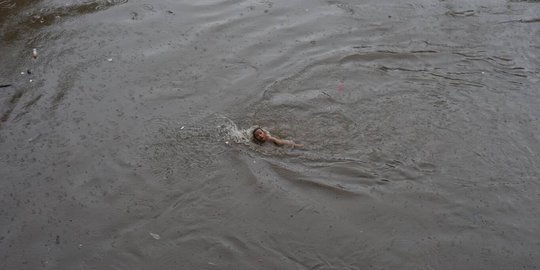 Hujan Deras, Anak-Anak Ini Nekat Berenang di Sungai Ciliwung