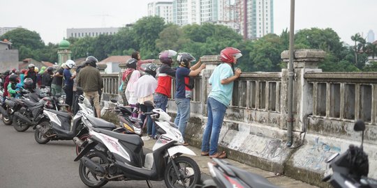 Banjir Ciliwung Jadi Tontonan Pemotor di Flyover Rawajati