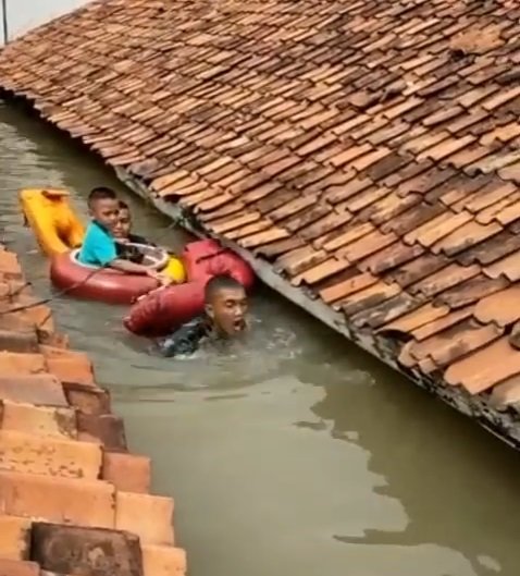 anggota marinir selamatkan balita terjebak banjir