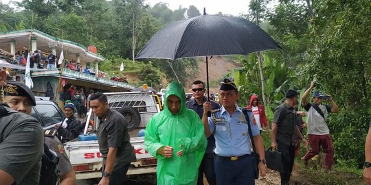 Kehujanan, Jokowi Pakai Jas Hujan Harga Rp10 Ribu saat Tinjau Longsor di Bogor
