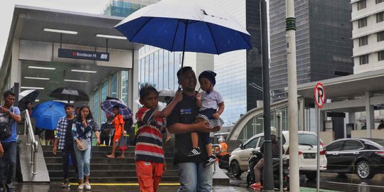Hujan Jadi Berkah Ojek Payung di Bundaran HI