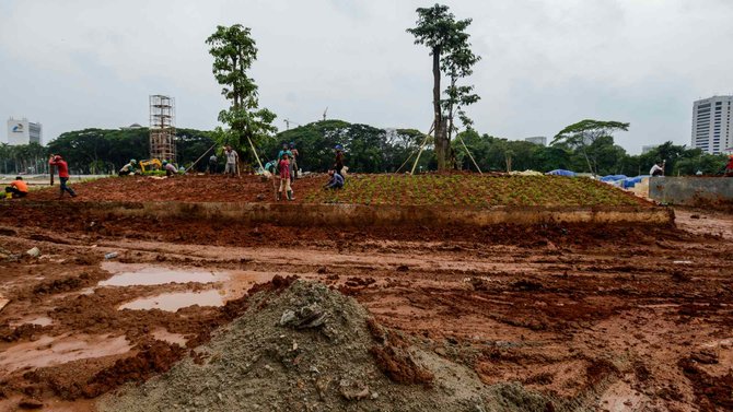 pekerja tanam pohon di taman monas