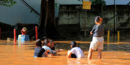Anak-Anak Bermain di Tengah Banjir