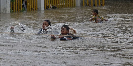 Saat Anak-anak Asyik Main Banjir di Jalan Raya Pondok Gede