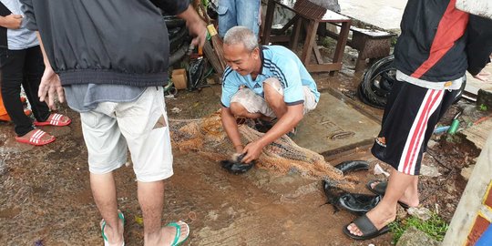 Warga Cipinang Menjala Ikan di Tengah Banjir