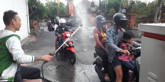 Pengunjung Pasar Badung Bali Disemprot Disinfektan Sebelum Ambil Karcis Parkir