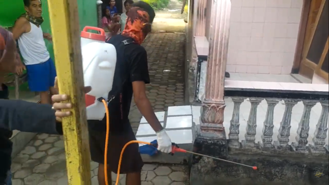 seorang warga melakukan penyemprotan disinfektan