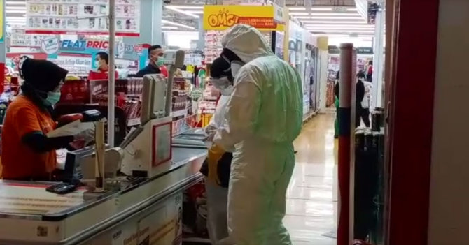 warga belanja di supermarket pakai baju hazmat