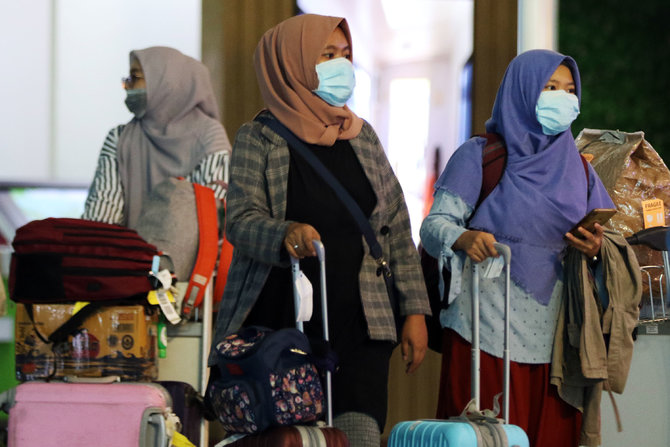 warga memakai masker di bandara