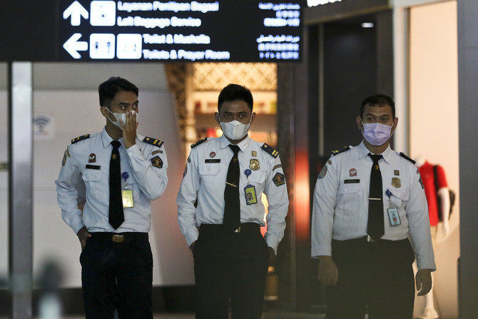 warga memakai masker di bandara