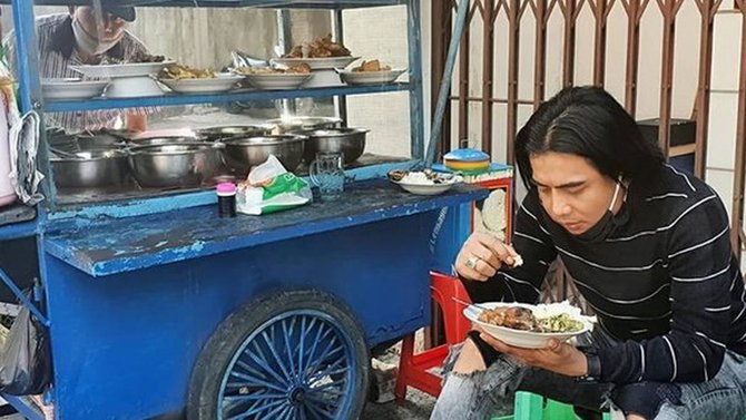 charly van houtten sedang makan di pinggir jalan