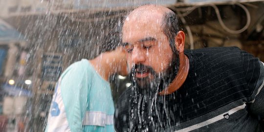 Suhu Panas Meningkat, Warga Irak Dinginkan Tubuh di Bawah Pancuran