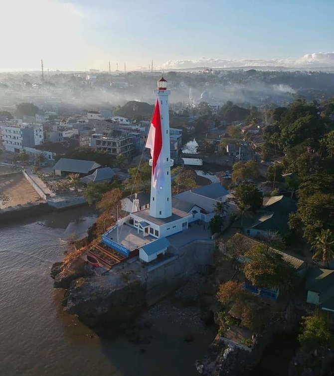 bendera merah putih raksasa berkibar di atas menara suar kupang
