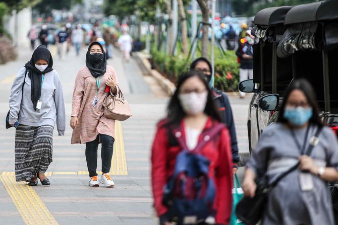 karyawan melintas di pedestrian sudirman