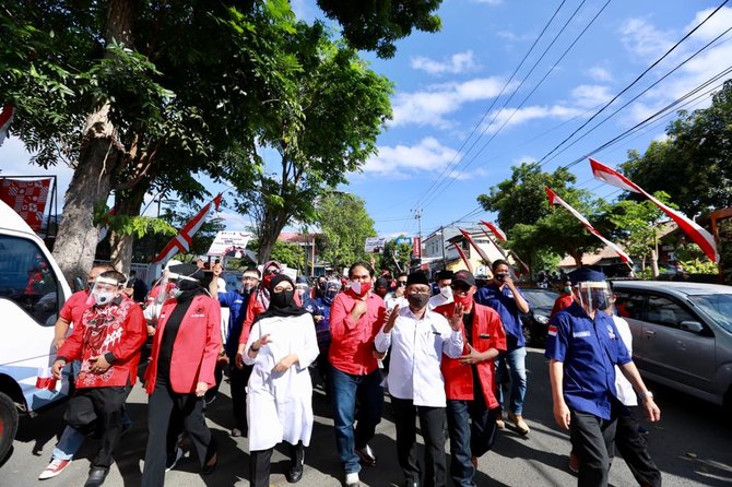 jalan kaki ke kpu banyuwangi ipuk fiestiandani dan sugirah disambut antusias warga