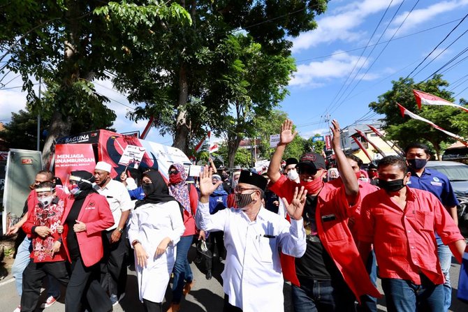 jalan kaki ke kpu banyuwangi ipuk fiestiandani dan sugirah disambut antusias warga