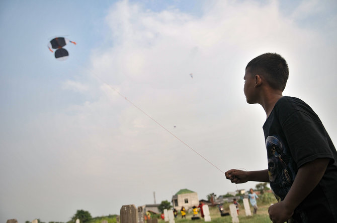 bermain layang layang di kuburan